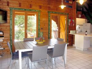 a dining room with a wooden table and chairs at Holiday Home L'Escouarte - MAU170 by Interhome in Maubuisson