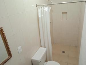 y baño con aseo y ducha con cortina de ducha. en Hotel Kiko, en Mazatlán