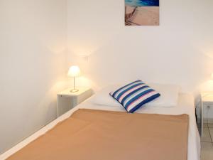 a bedroom with a bed with a striped pillow on it at Apartment Résidence Belle Dune - BPL331 by Interhome in Biscarrosse-Plage