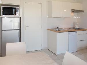 Una cocina con un refrigerador blanco y un fregadero. en Apartment Résidence Belle Dune-2 by Interhome, en Biscarrosse-Plage