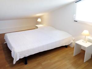 Un dormitorio con una cama blanca y dos mesas. en Apartment Résidence Belle Dune-2 by Interhome, en Biscarrosse-Plage 11 fotos más