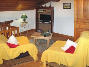 sala de estar con 2 sillas y TV en Holiday Home Chez Nancy - ABE300 by Interhome, en Blesle