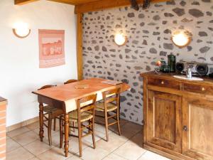 een keuken met een houten tafel en een aantal stoelen bij Holiday Home Chez Nancy - ABE300 by Interhome in Blesle