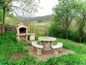 a picnic table and two benches next to a oven at Holiday Home Varenne - ABL100 by Interhome in Blassac