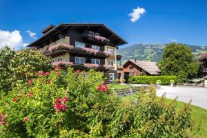 a large house with flowers in front of it at Garni Rösslhof in Hollersbach im Pinzgau