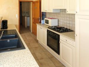 a kitchen with a stove and a microwave at Holiday Home La Cardeline by Interhome in Grillon +6 photos