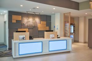 a lobby with a counter with boxes on it at Holiday Inn Express Doral Miami, an IHG Hotel in Doral