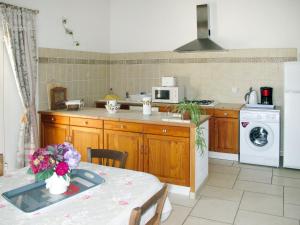 a kitchen with a table and a stove and a microwave at Holiday Home Les Vignes - MBE100 by Interhome in Ménerbes