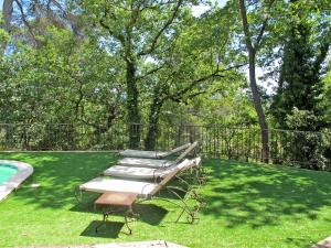 ドラギニャンにあるHoliday Home L'Esquirou - DRA110 by Interhomeのプール横の芝生に座る長椅子