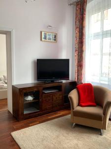 - un salon avec une télévision à écran plat et une chaise dans l'établissement Apartament Mariana Mokwy 6b, à Sopot