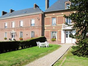 a house with a table and chairs in front of it at Holiday Home Le Domaine du Vasouy by Interhome in Colleville