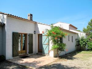 レギュスにあるHoliday Home La Bignone - REG130 by Interhomeの花の茂みと扉のある白い家