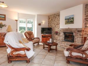 ein Wohnzimmer mit Stühlen und einem Steinkamin in der Unterkunft Holiday Home Ty Breiz by Interhome in Ploemeur