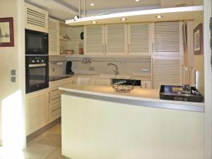 パンマールにあるHoliday Home Ty Pors Ar Pagn - PEM119 by Interhomeの白いキャビネット、シンク、カウンター付きのキッチン