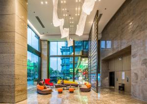 a lobby with couches and chairs in a building at Holiday Inn Express Shenzhen Nanshan by IHG in Shenzhen
