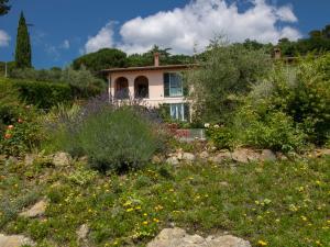 een huis midden in een tuin met bloemen bij Villa Olindia by Interhome in San Savino