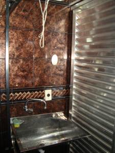 a bathroom with a sink and a metal wall at Apart Marcelo - Lapa/Rezende in Rio de Janeiro