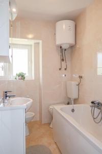 a bathroom with a tub and a toilet and a sink at Holiday Home Antica by Interhome in Punat