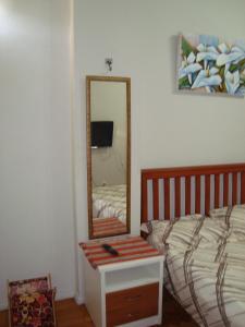 a bedroom with a bed and a mirror on the wall at Apart Marcelo - Lapa/Rezende in Rio de Janeiro