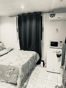 una camera da letto con un letto con una tenda nera di Chambre SEJOUR a Dakar