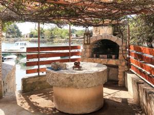 una mesa de piedra con un horno de piedra en un patio en Holiday Home Delfar - LSJ100 by Interhome, en Nerezine