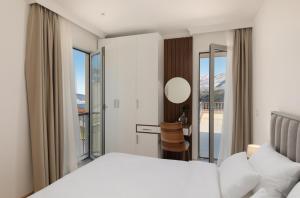 a bedroom with a bed and a large window at Carsko Selo Blizikuce in Budva