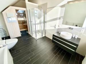 a bathroom with a toilet and a sink and a shower at mönchgut living & spa in Gager