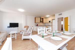 a living room with a table and chairs and a kitchen at Apartamento Vora Mar 33 in Cambrils