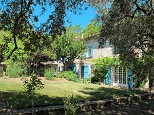 een huis in het midden van een tuin met bomen bij Holiday Home Mas de l'Adrech by Interhome in Fayence