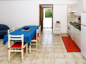 uma cozinha e sala de jantar com uma mesa azul e cadeiras em Apartment Martina - KOR301 by Interhome em Prizba