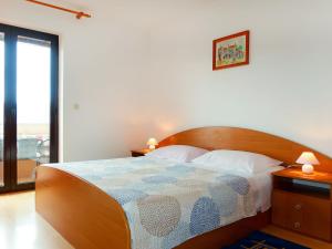 a bedroom with a bed with a wooden head board at Apartment Rosić - KRK218 by Interhome in Kornić