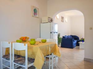 a kitchen with a table with chairs and a refrigerator at Apartment Rosić - KRK218 by Interhome in Kornić
