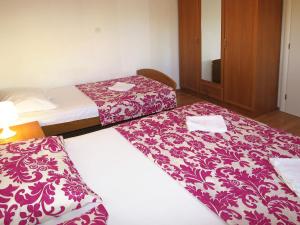 two beds in a hotel room with red and white blankets at Apartment Klarić-1 by Interhome in Trogir