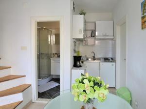 a kitchen with a glass table with a vase of flowers at Apartment Klarić-1 by Interhome in Trogir