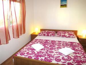 a bedroom with a bed with a red and white blanket at Apartment Klarić-1 by Interhome in Trogir