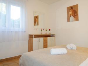 a white bedroom with a bed with towels on it at Apartment Meri - KRK211 by Interhome in Kornić