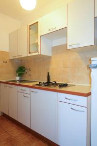 a kitchen with white cabinets and a sink at Apartment Meri - KRK211 by Interhome in Kornić