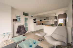 una sala de estar con un sofá y una mesa en Appartementencomplex Juliana 132, en De Koog