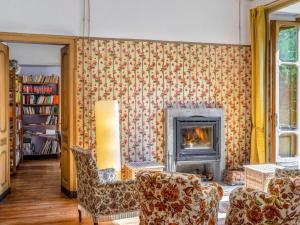 - un salon avec une cheminée et 2 chaises dans l'établissement Holiday Home Villa Biino - VIZ200 by Interhome, à Ala di Stura