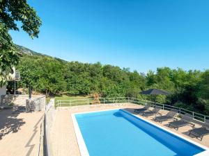 a swimming pool with two chairs and an umbrella at Holiday Home Mazor - NOV400 by Interhome in Bribir