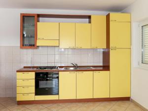 a kitchen with yellow cabinets and a sink at Apartment Buda - HVR217 by Interhome in Basina