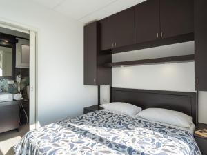 ein Schlafzimmer mit einem großen Bett mit braunen Schränken in der Unterkunft Holiday Home Bouganvilla - SLR402 by Interhome in San Lorenzo al Mare