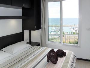 ein Schlafzimmer mit einem Bett und einem großen Fenster in der Unterkunft Holiday Home Bouganvilla - SLR402 by Interhome in San Lorenzo al Mare