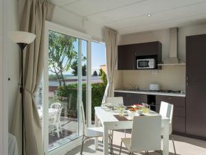 eine Küche und ein Esszimmer mit einem weißen Tisch und Stühlen in der Unterkunft Holiday Home Bouganvilla - SLR402 by Interhome in San Lorenzo al Mare
