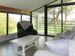 a living room with a table and a couch and windows at Holiday Home Le Chomeil by Interhome in Chamalières-sur-Loire +11 photos