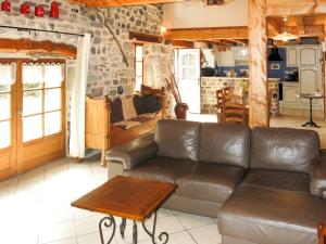 a living room with a leather couch and a table at Holiday Home Le Chomeil by Interhome in Chamalières-sur-Loire
