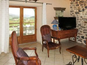 a living room with a tv and a desk with a computer at Holiday Home Le Chomeil by Interhome in Chamalières-sur-Loire