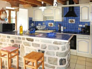 a kitchen with a stone counter top and blue tiles at Holiday Home Le Chomeil by Interhome in Chamalières-sur-Loire