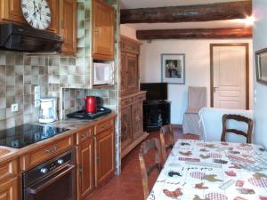 a kitchen with a table and a clock on the wall at Apartment Mas du Combaud-1 by Interhome in Roquebrune-sur-Argens