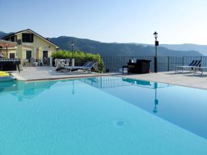 una grande piscina con acqua blu di fronte a una casa di Apartment Viola - VLO203 by Interhome a Lecchiore